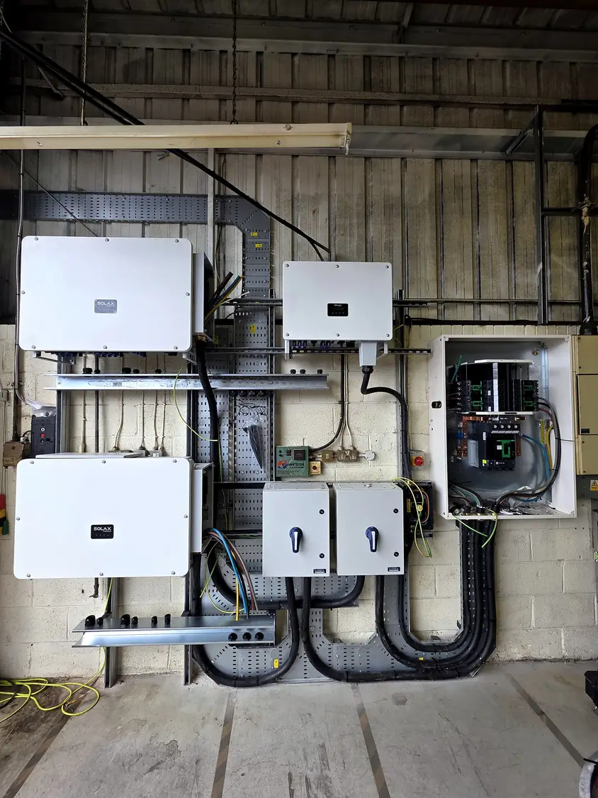 Completed inverter station: three Solax inverters with AC isolators