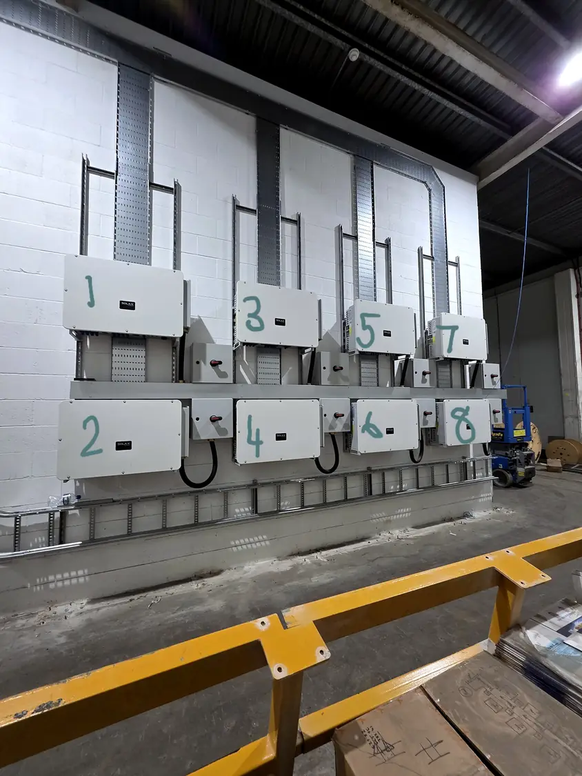 One of two inverter rooms: eight 100 kW inverters with AC isolators, numbered 1–8