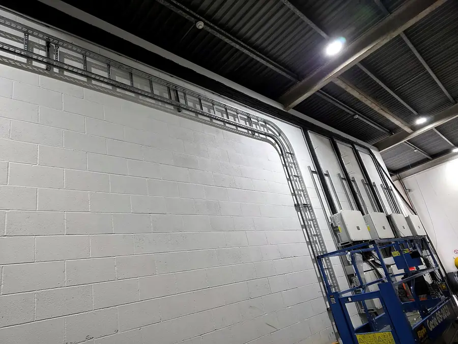 Ladder rack along the top of the wall and down to the inverters